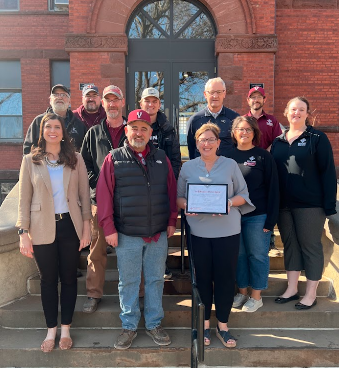 Kim receiving award from facilities services and staff senate members