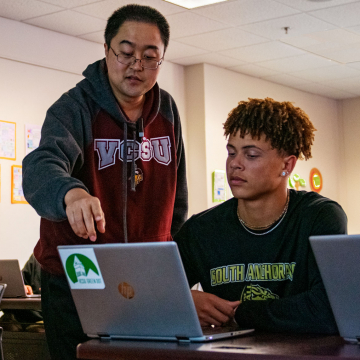 student working on computer with professor