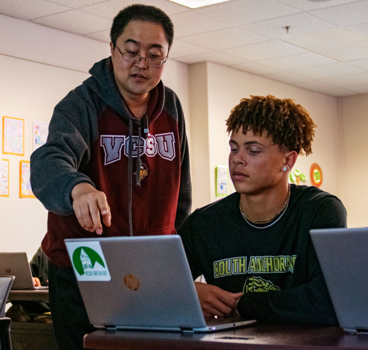 student working on computer with professor