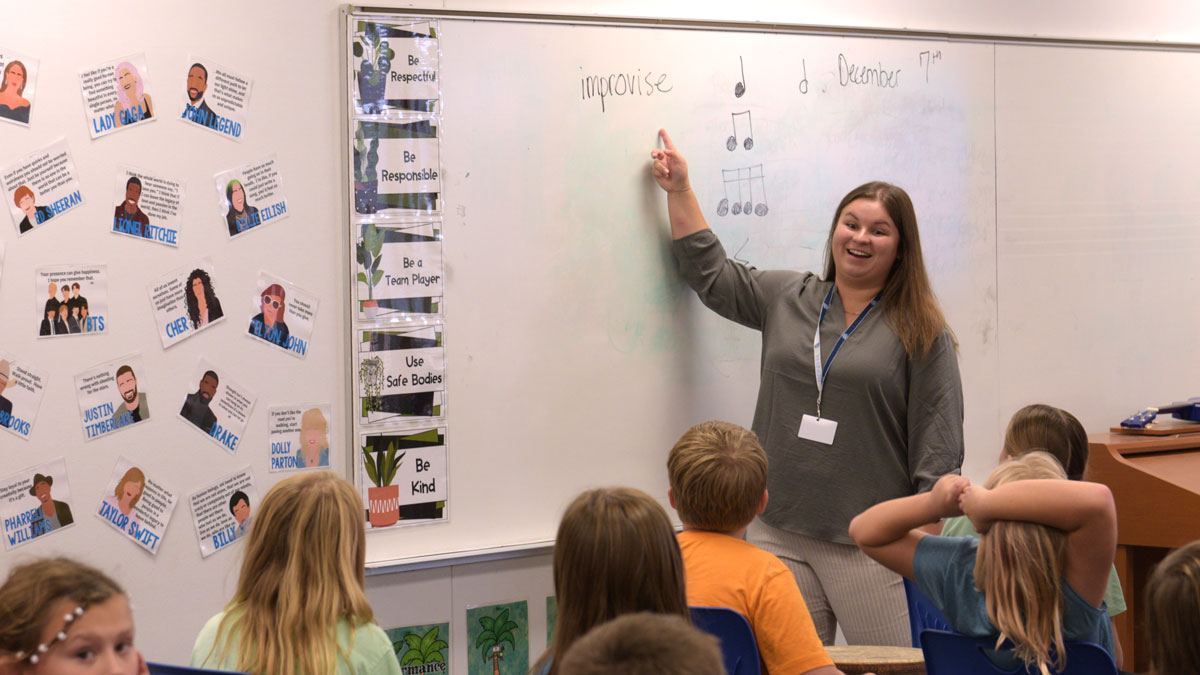 A teacher working with students in a music class in an elementary school.