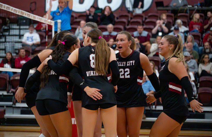 volleyball players celebrating in team huddle
