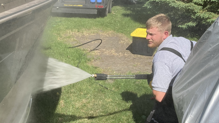 Ben Holen, VCSU graduate and North Dakota's Aquatic Nuisance Species coordinator, sprays a boat down to prevent the spread of zebra mussels