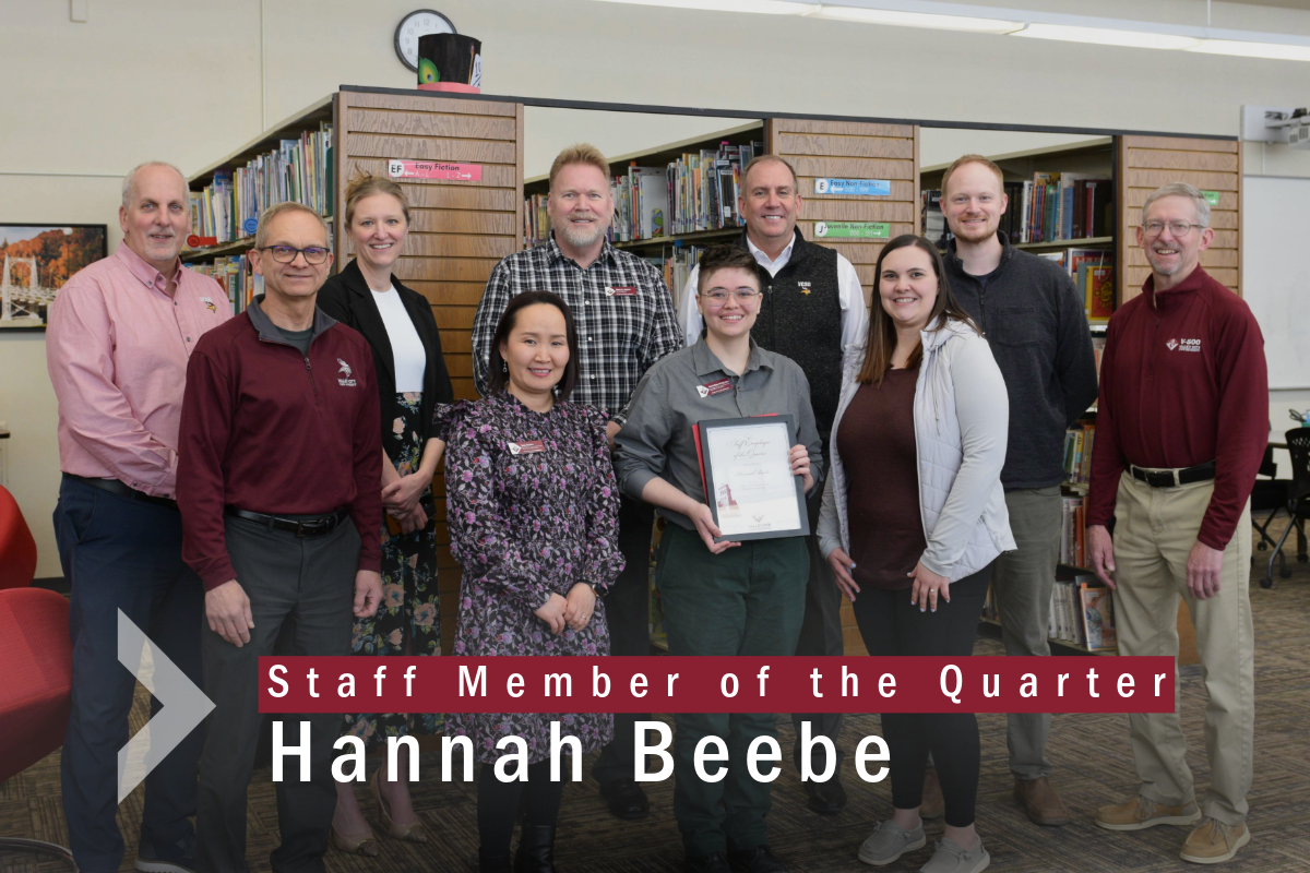 Hannah receiving award from group with text: Staff Member of the Quarter Hannah Beebe