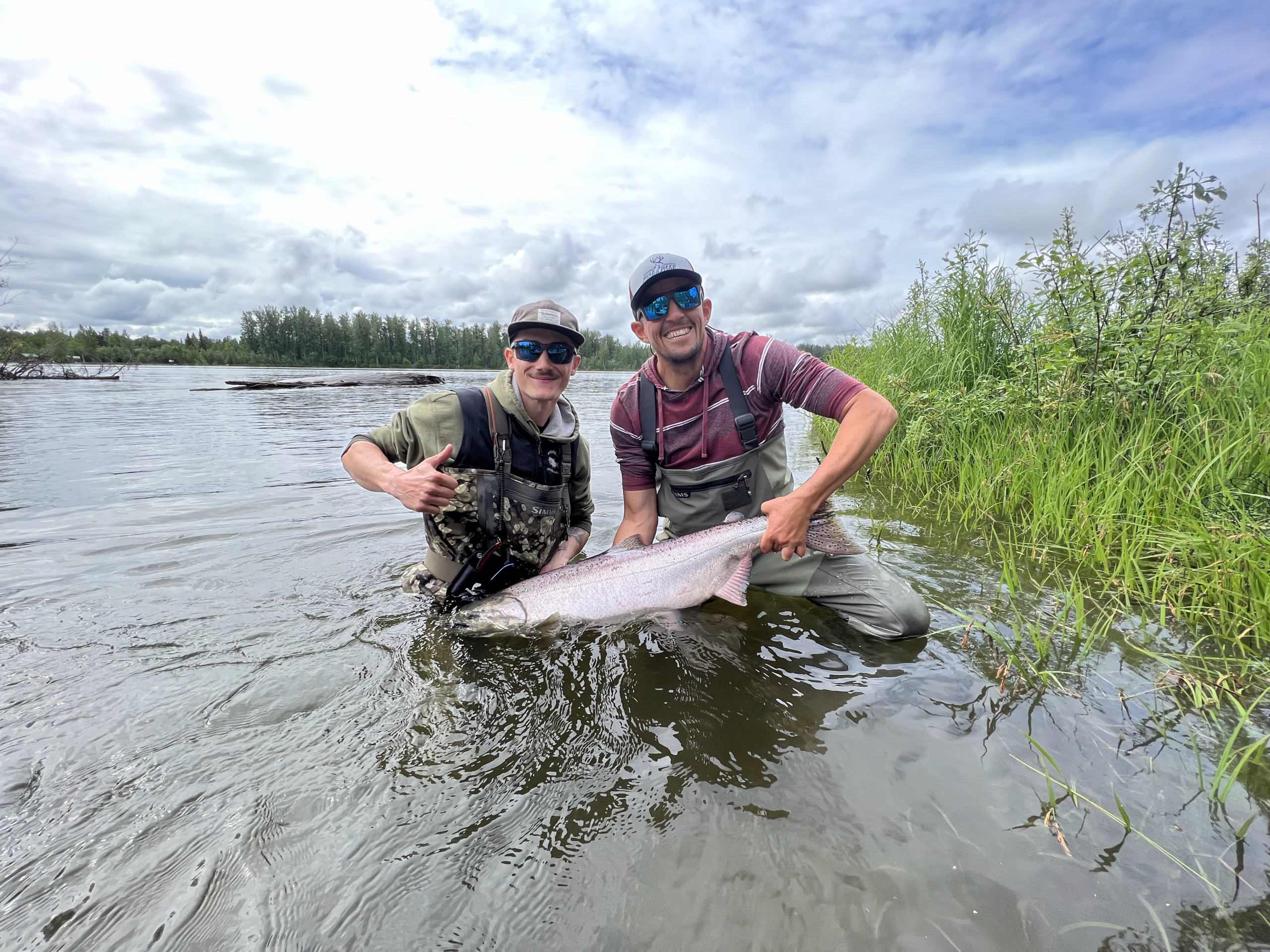 Photo of Dylan Kibel and male mentor holding a fish and smiling at the camera