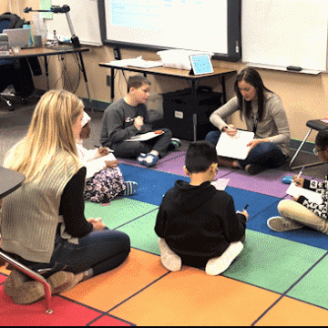 Students listen to a teacher in an elementary school classroom