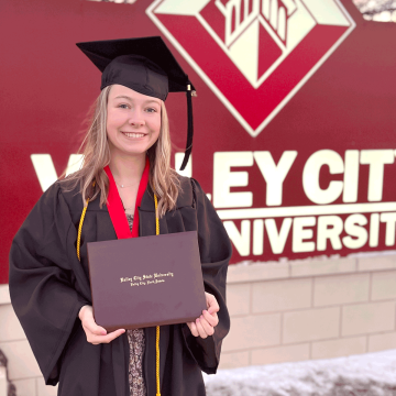 Emma Nielsen holding her diploma from VCSU