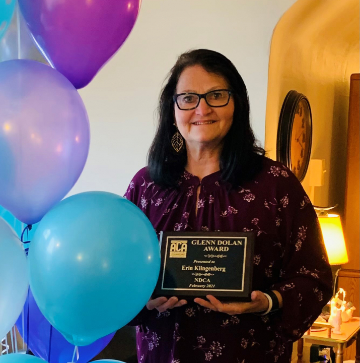 Erin holding award with balloons