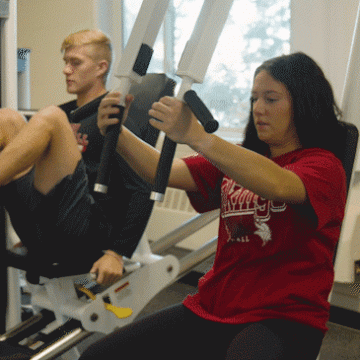 Two students exercising in a weight room at Valley City State University
