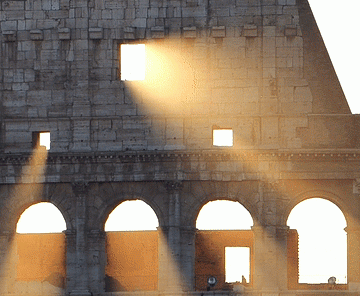 Panning video of the Colosseum with light streaming through the archways.