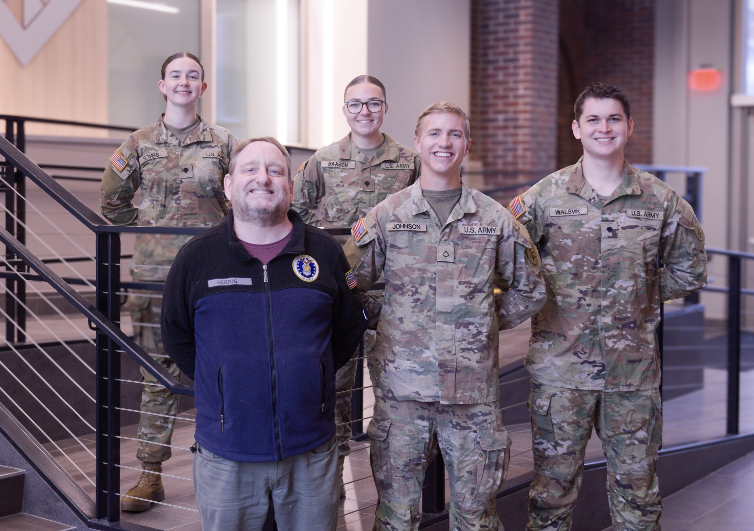 Group photo of four military students and their campus advisor