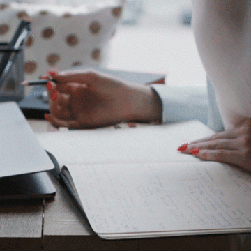 A graduate student studying and turning the page of their notebook.