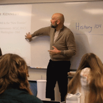 VCSU History professor Anthony Dutton teaches a class in front of a white board.