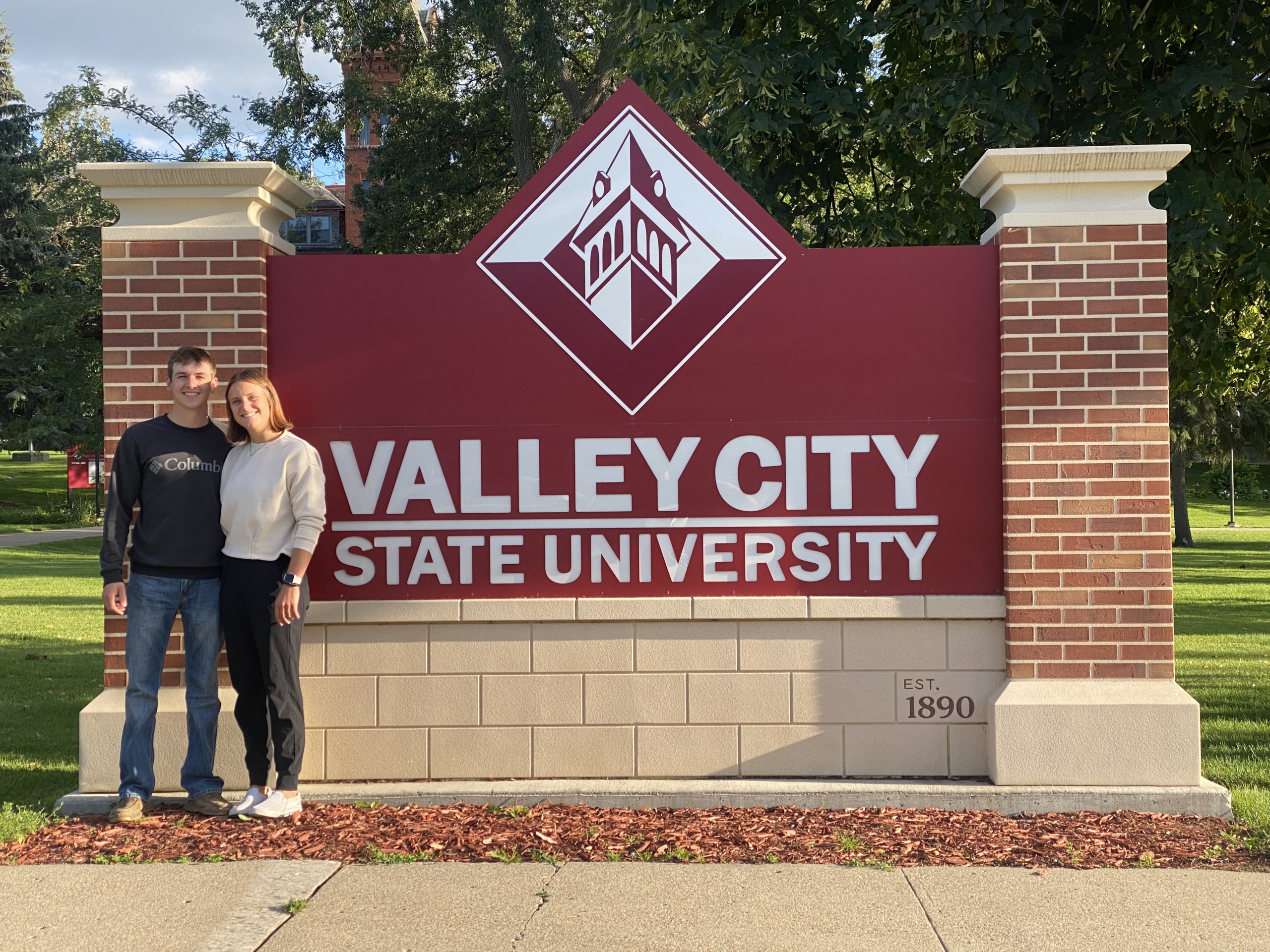 Photo of Kathleen Vetter and a male VCSU student in front of the VCSU welcome sign