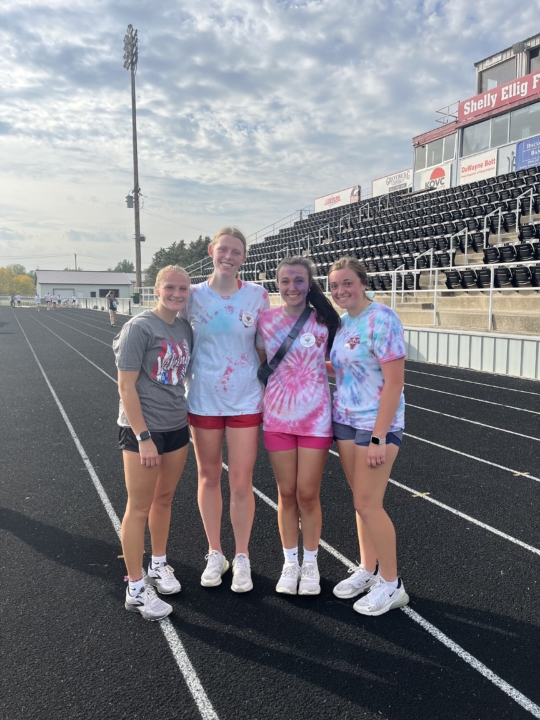 Alliana Freund smiling at the camera alongside three VCSU female students