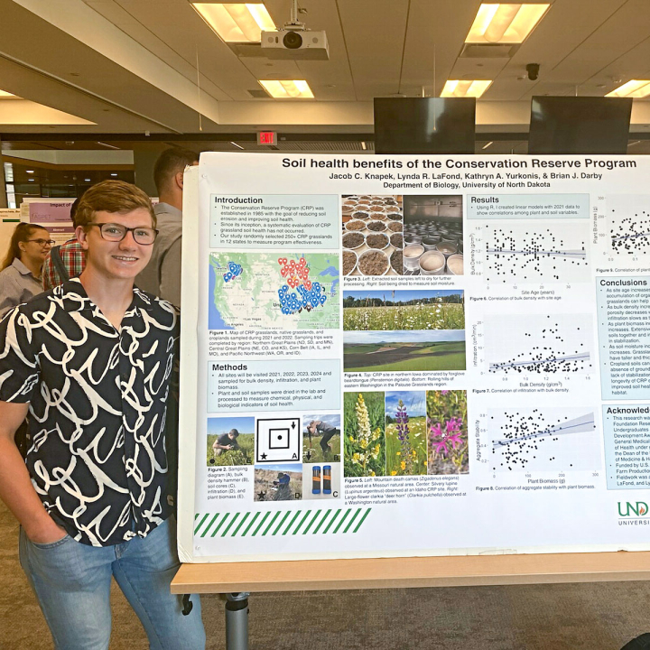 Jacob standing next to his research poster