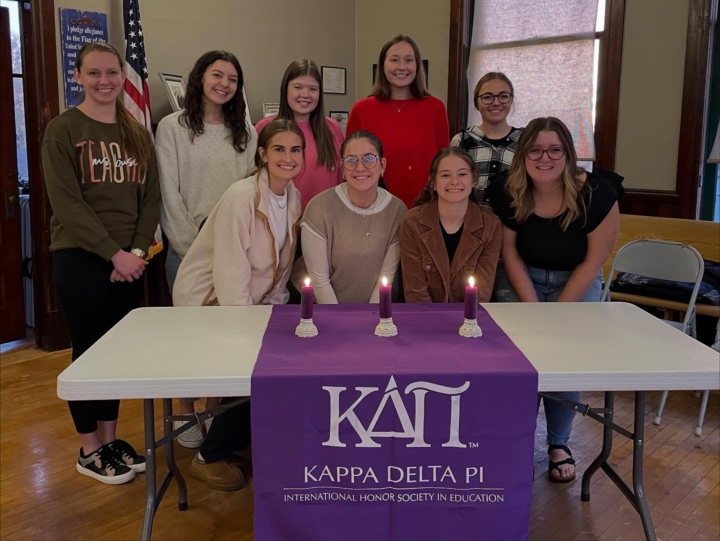 KDP members sitting at table with banner