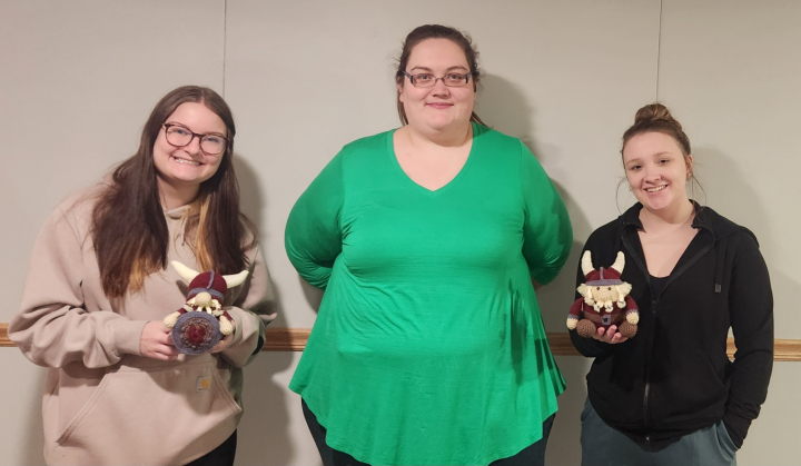 VCSU students Piper Hanna and Ellie Rush hold crocheted Vikings made by Aleisha Kiser