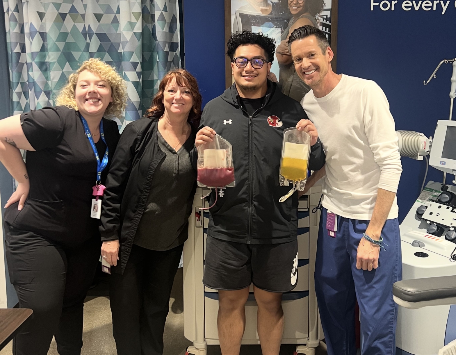 Photo of three nurses and Loke Iese smiling at the camera