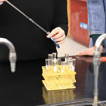 female student demonstrating with dropper and test tube