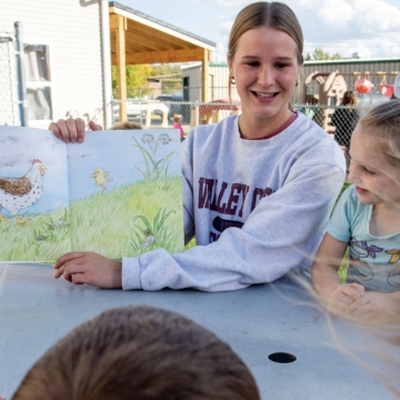 Mathea reading to a group of young children