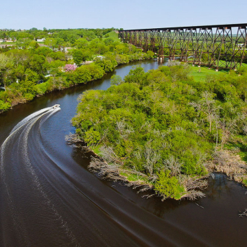 A boat motors down the Sheyenne River under the HiLine bridge in Valley City