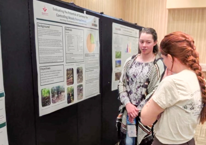 Janet presenting poster to conference attendee