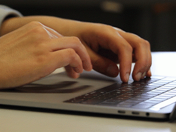 individual typing on computer keyboard