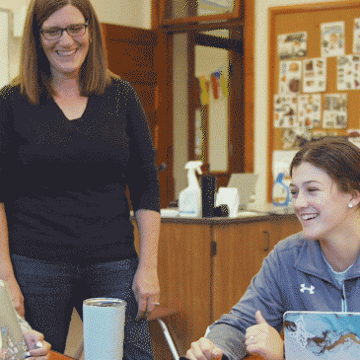 A psychology professor works with a student during class