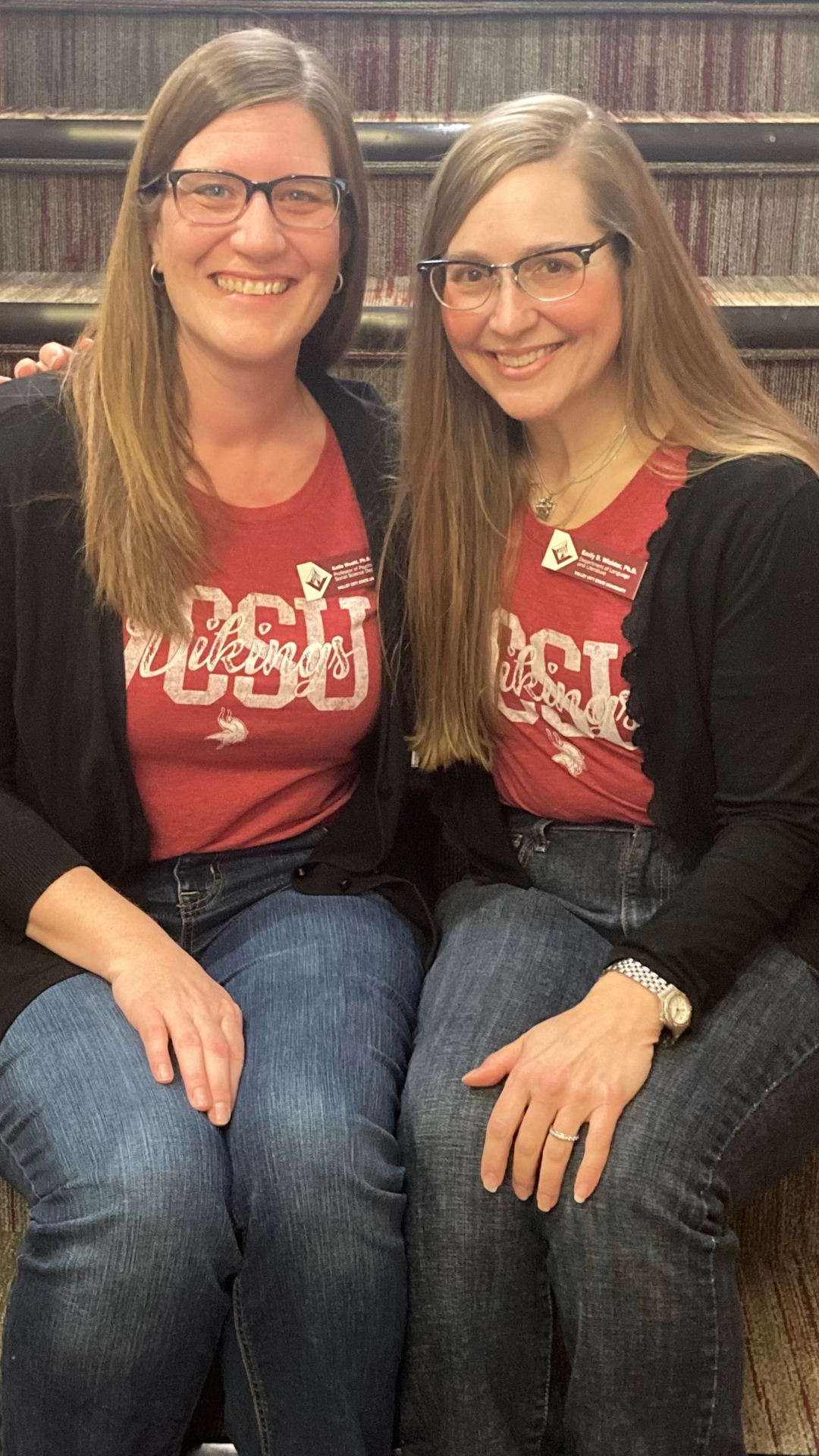 Professor Katie Woehl and Professor Emily Wicktor sit on the steps in McFarland