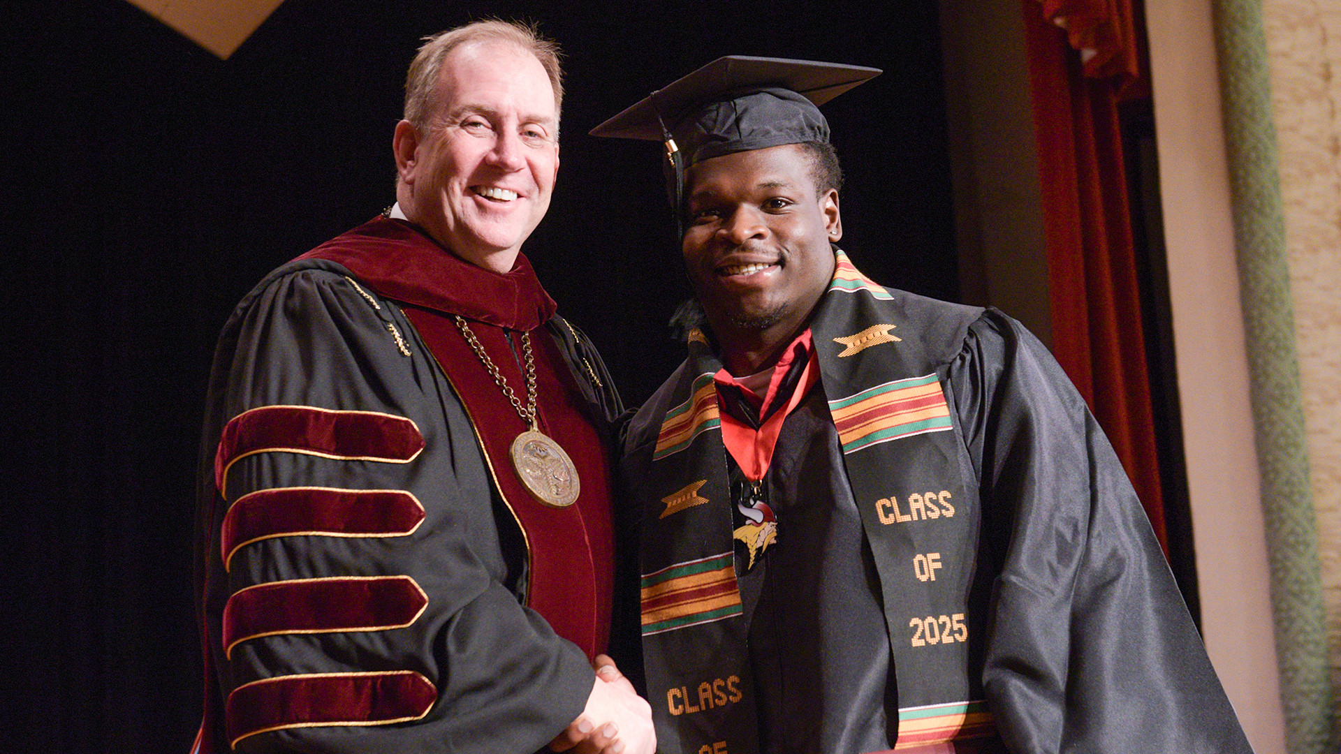 President Alan LaFave shakes the hand of graduate Taquez Chatman