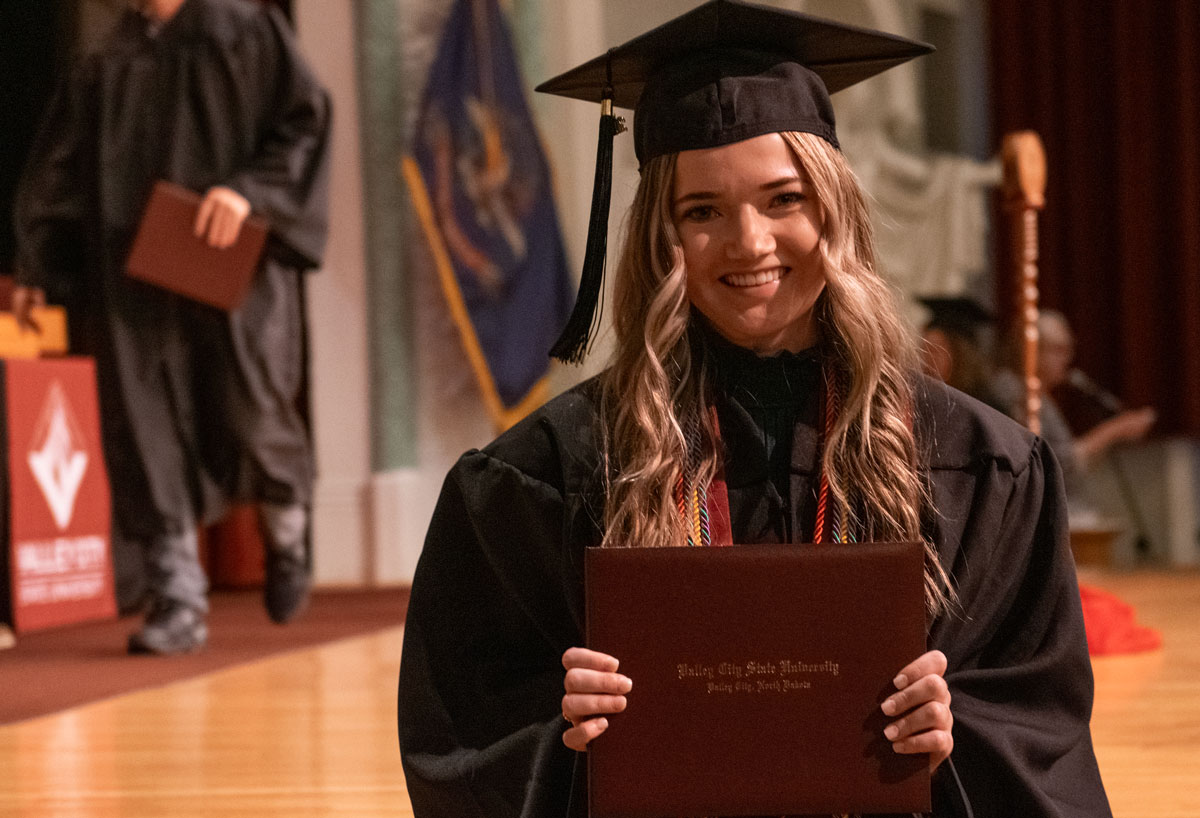 A graduate with her degree during the 2023 Winter Commencement