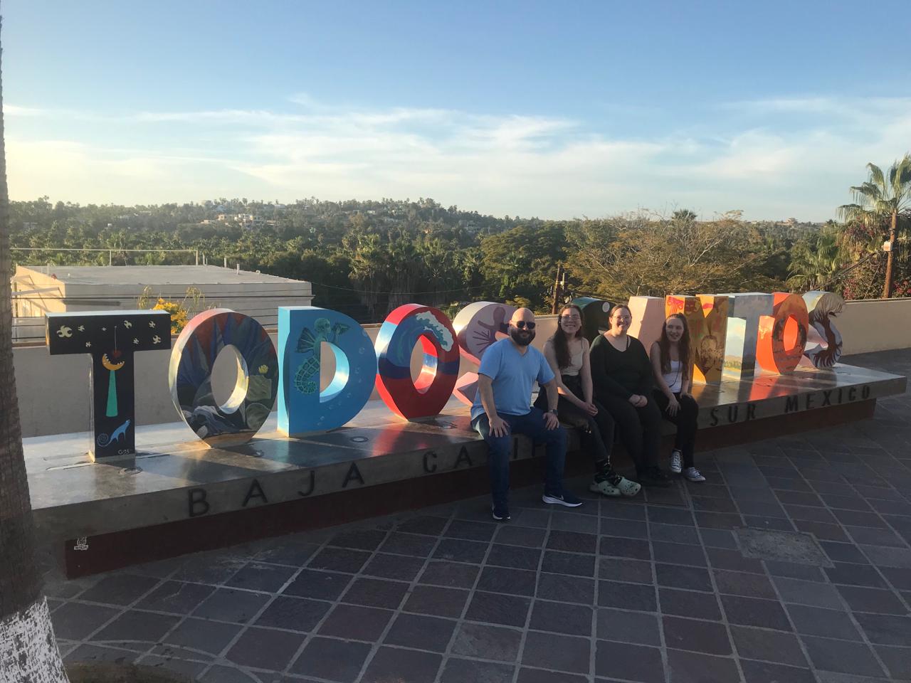 Trip attendees pose for a photo in from of the landscape