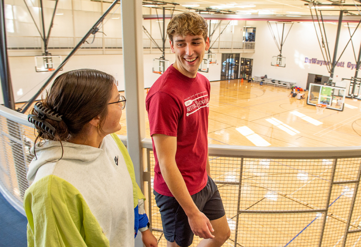 male and female student on walking track in wellness center