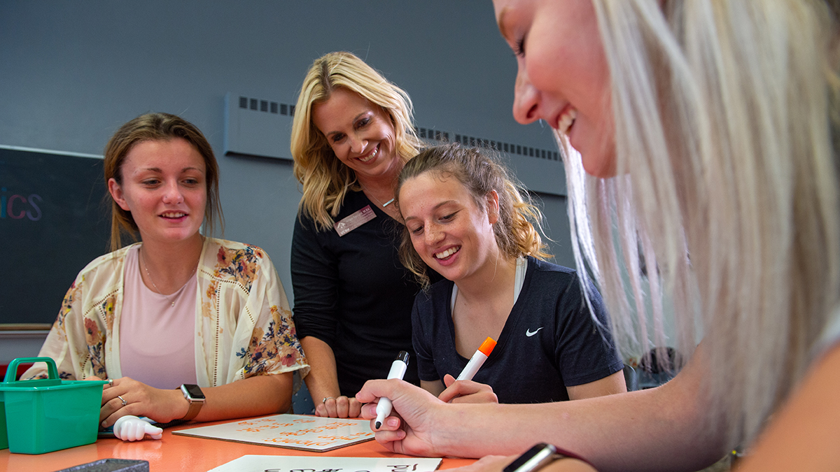 female professor working with three female students in the education department