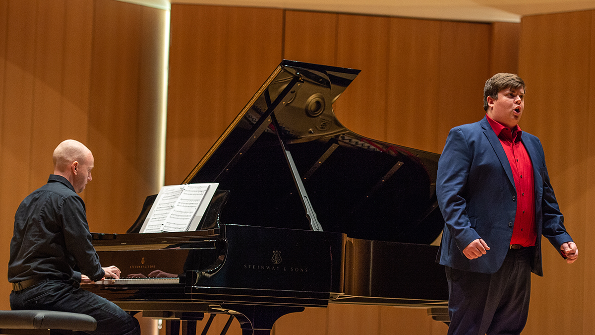 Male student singing along side male pianist