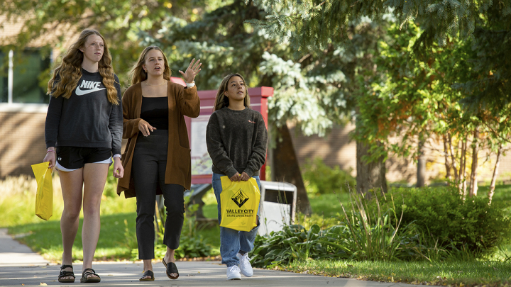 Female advisor giving two female students a tour of campus