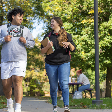 Male and female student walking outside