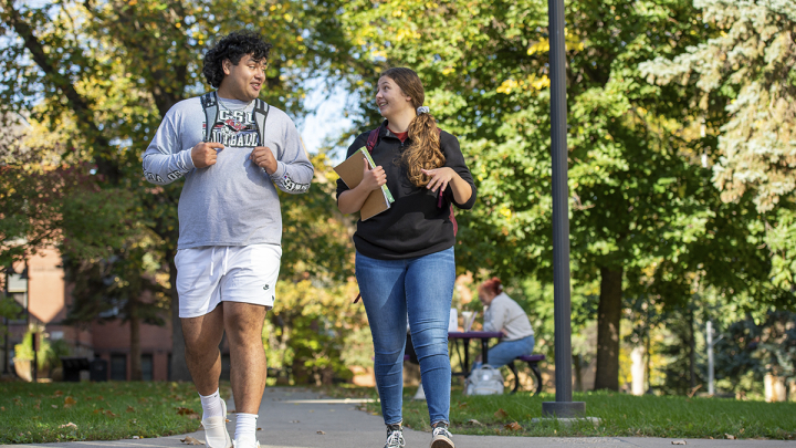 Male and female student walking outside