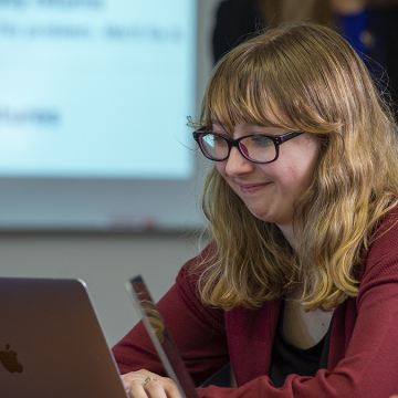 Female student smiling at computer