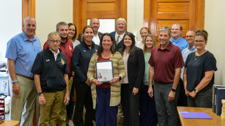 Chasity Lovell holding award, pictured with other staff and faculty members