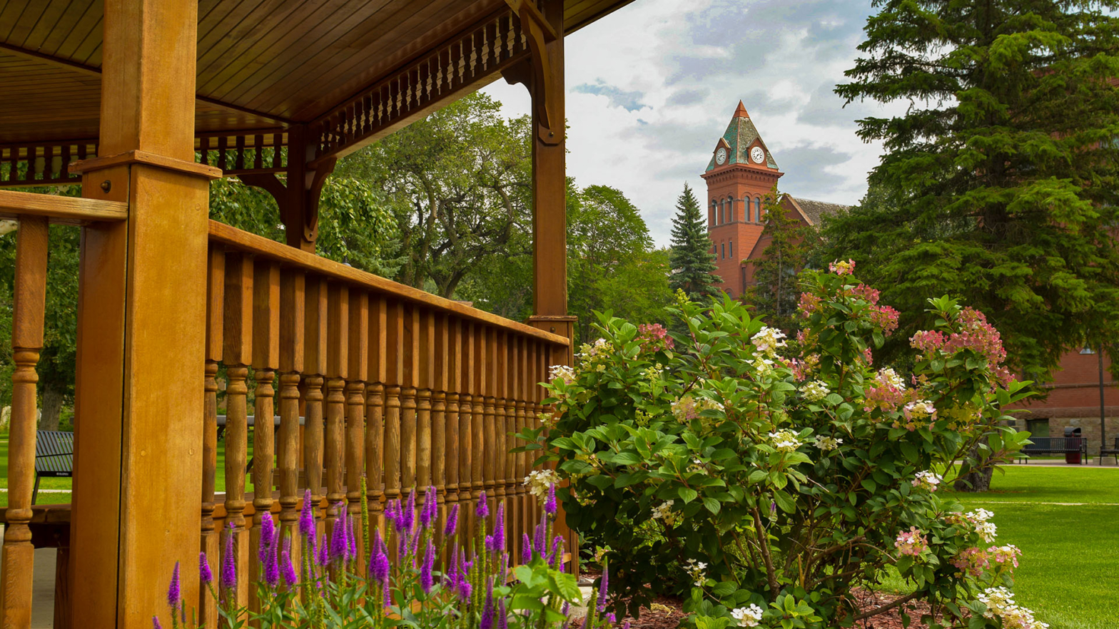 Photo of outdoor gazebo railing with plants and the VCSU clocktower in the background