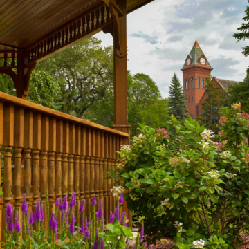 Photo of outdoor gazebo railing with plants and the VCSU clocktower in the background