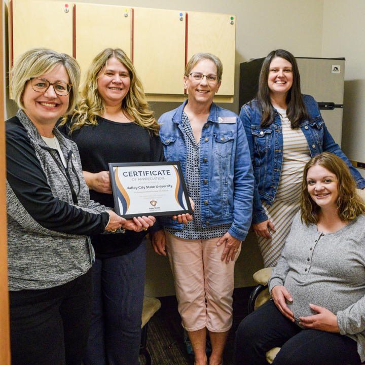 people holding certificate in mothers room