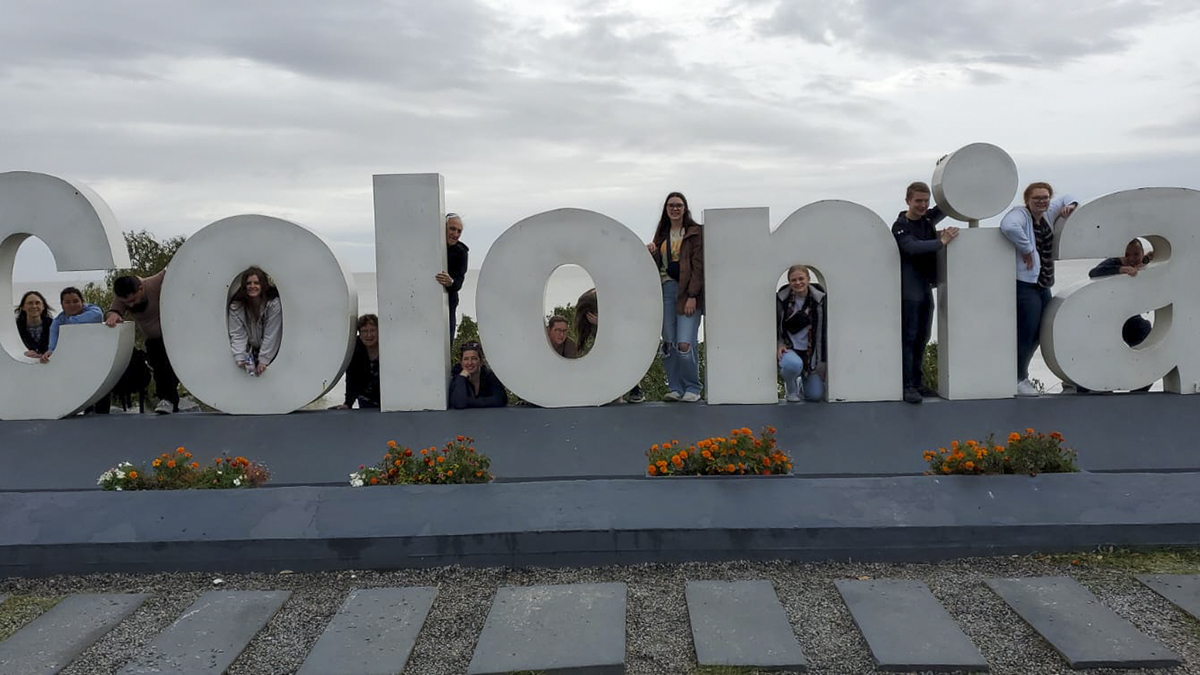 group posing with Colonia sign