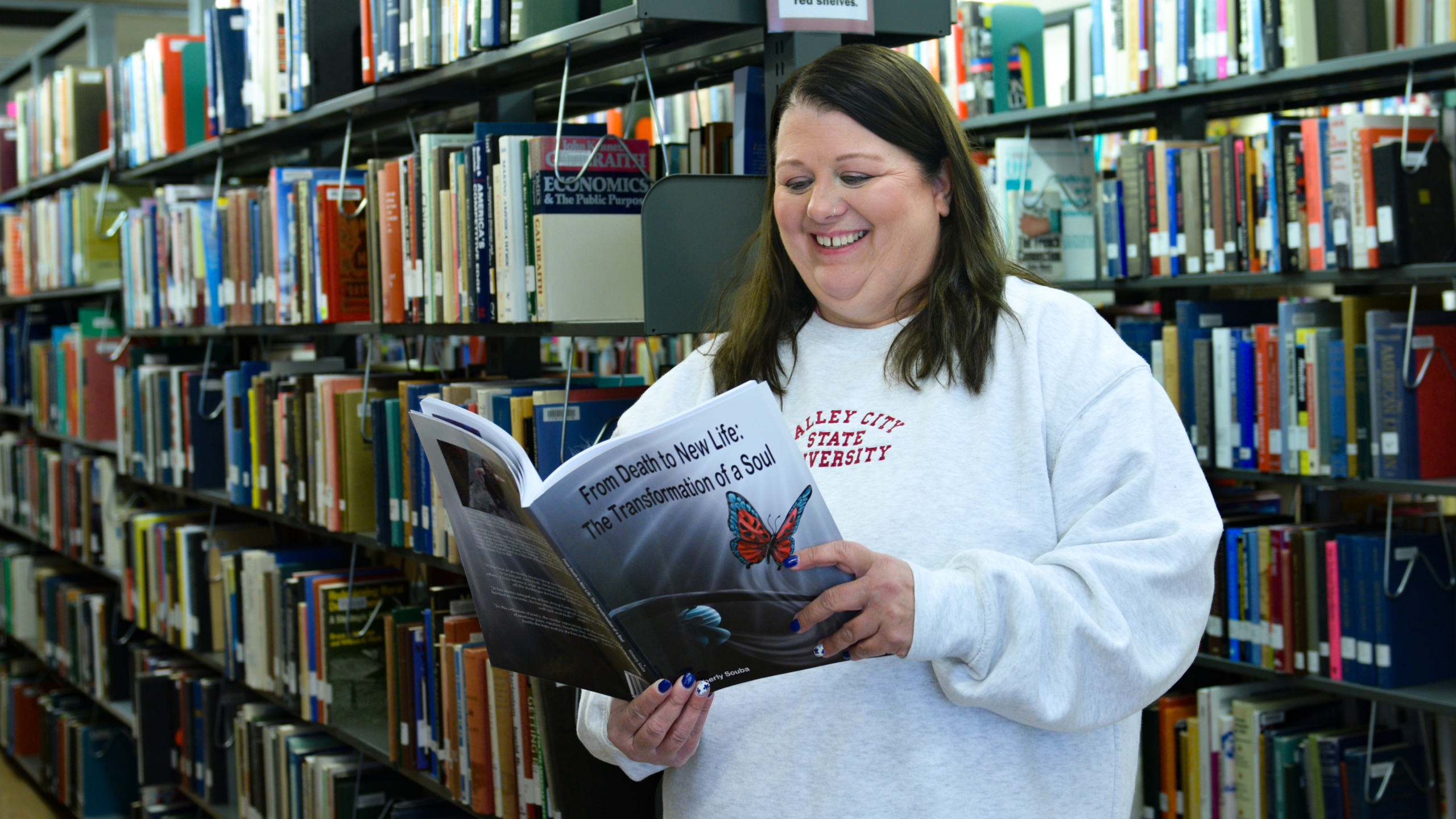 Photo of Kimberly Souba reading her book "From Death to New. Life: The Transformation of a Soul" 