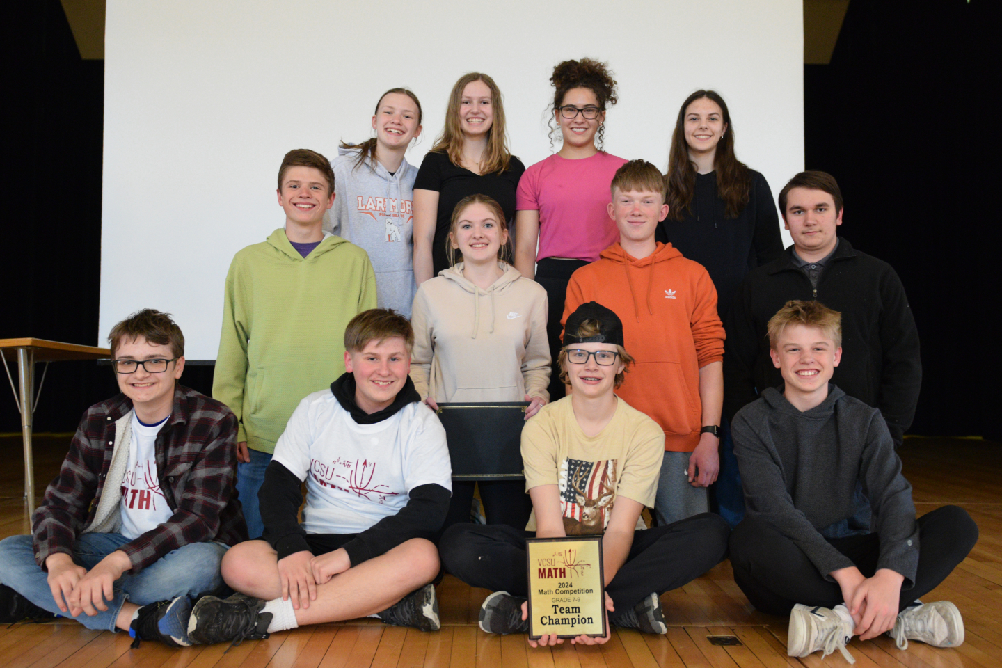 Award winners pose for a photo with a plaque