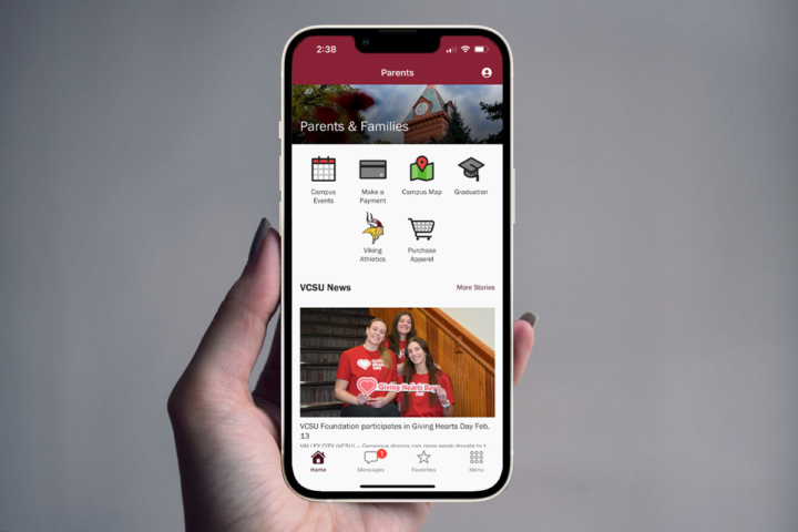A hand holding an iPhone showing the myVCSU app