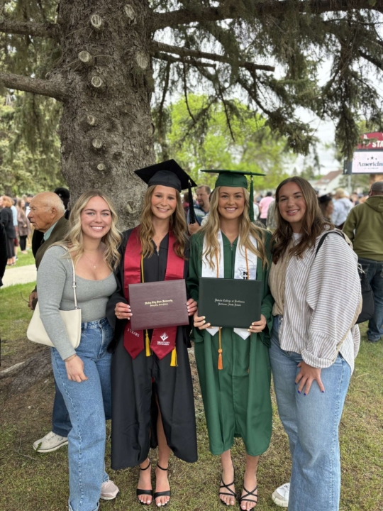 Megan Lahtonen smiling at the camera with one female VCSU student and two VCSU female graduates