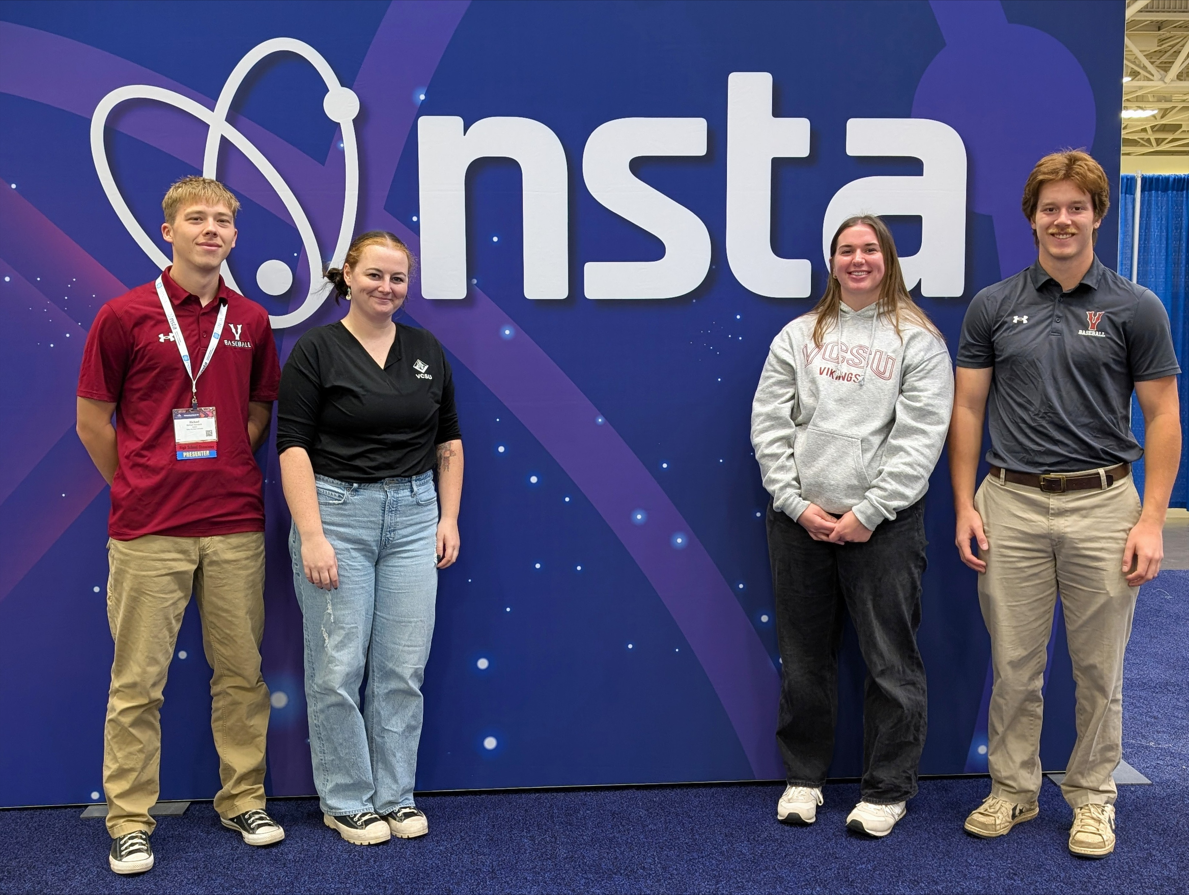 Megan Lahtonen smiling at the camera with two male VCSU students and one female VCSU student