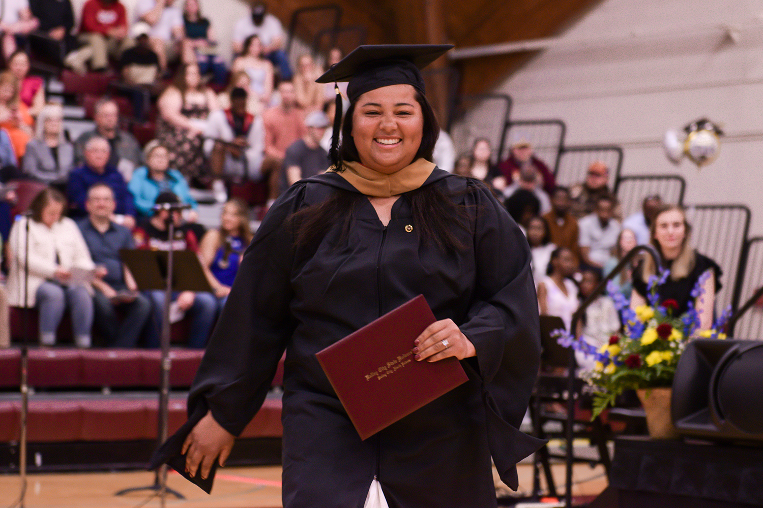 Riley Perryman in cap and gown with diploma in hand